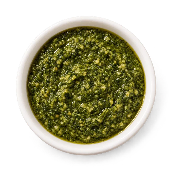 Green pesto sauce in a small white bowl